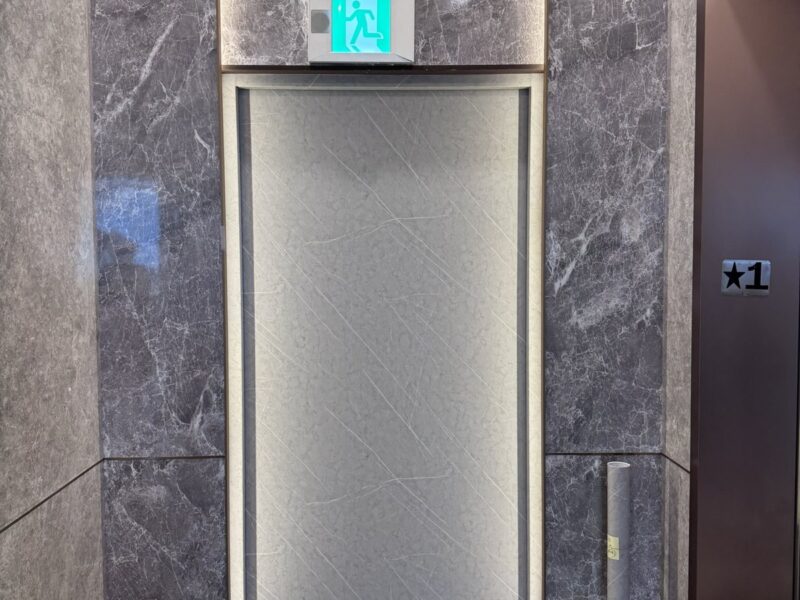 一樓電梯廳防火門改大理石紋,與石材牆面相融